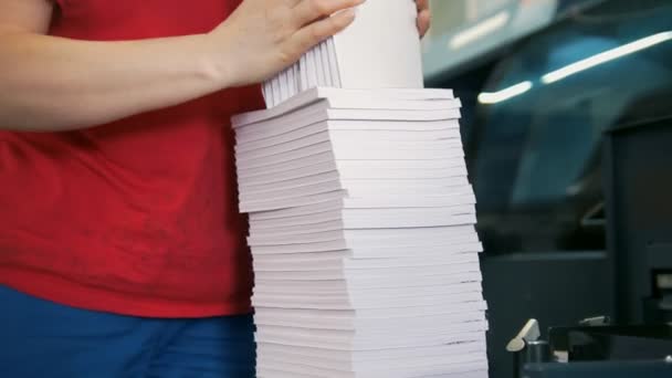 As mãos do funcionário feminino dobram uma pilha de papel na tipografia — Vídeo de Stock