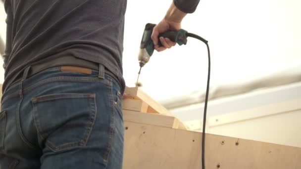 Artesano con destornillador girando el tornillo en la madera — Vídeo de stock