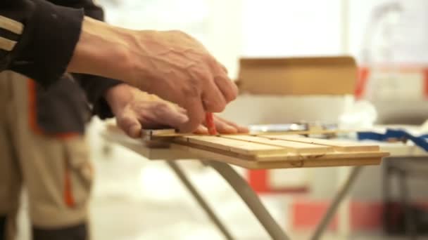 Hands of male carpenter makes a marker on the wood — Stock Video