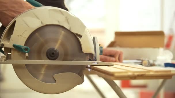 Carpenter working with circular blade sawing the wooden piece — Stock Video