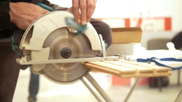 Чоловічі руки використовують циркулярне лезо для розпилювання дерев'яного шматка — стокове відео