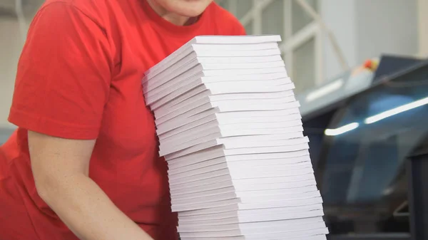 Hands of female worker folds a paper stacks in typography — Stock Photo, Image