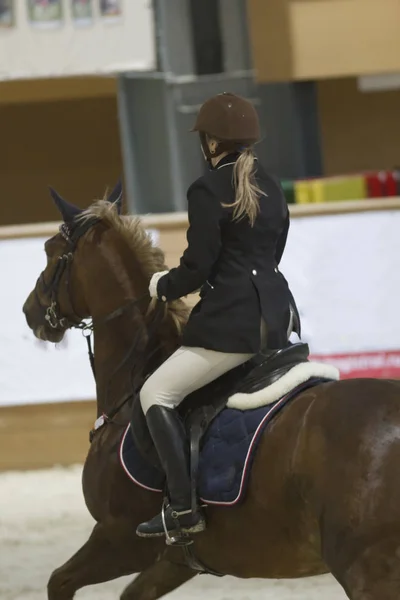 Visão traseira do cavaleiro equestre feminino correndo em garanhão na competição show jumping — Fotografia de Stock