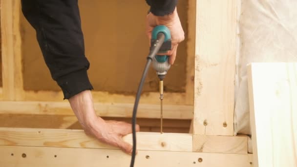 Männliche Hand arbeitet mit Stahlbohrer und Schraubenzieher auf Holzplatte — Stockvideo
