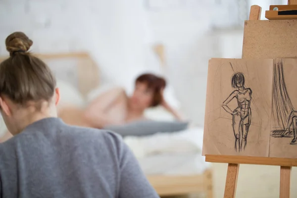 Vista trasera de pintora dibuja bocetos de mujer desnuda en clase de dibujo —  Fotos de Stock