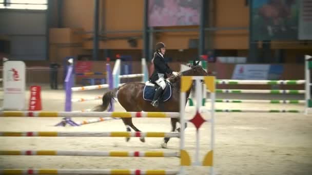 Kazan, Rusland - 25 April 2018: Paardensport championship - jonge vrouw op haar hengst springen over de horde — Stockvideo