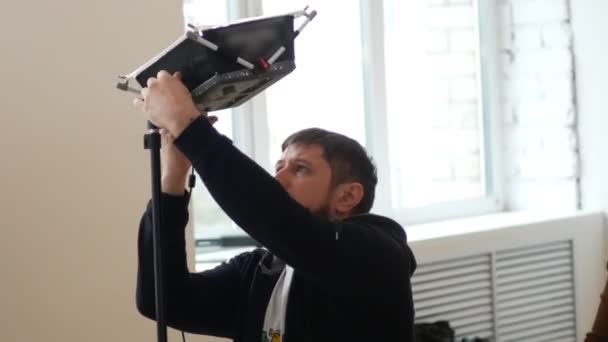 Kameraman bir stüdyoda profesyonel aydınlatma ayarlar — Stok video
