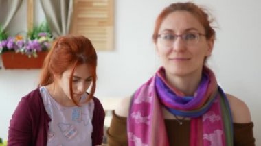 Oturma odasında gülümseyen iki beyaz genç kadın