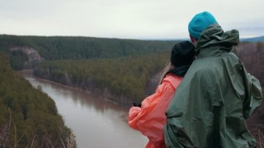 Genç çift ayakta hillside dağ nehir enjoing üzerinde güzel doğası