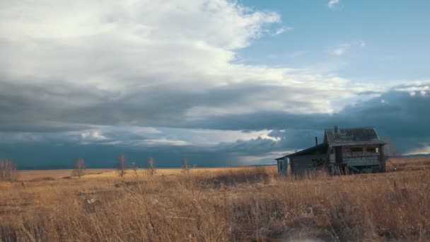 Маленький одинокий домик на фоне облачного неба в весеннем поле, временной промежуток — стоковое видео