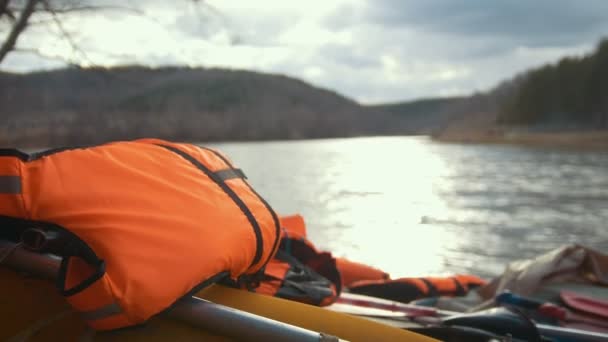 Chaleco salvavidas en el catamarán inflable en el fondo del río de montaña — Vídeos de Stock