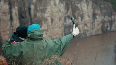 Selfie yapma Nehri üzerinde bir uçurumun kenarında oturan arka görünümü kaç yürüyüşçü