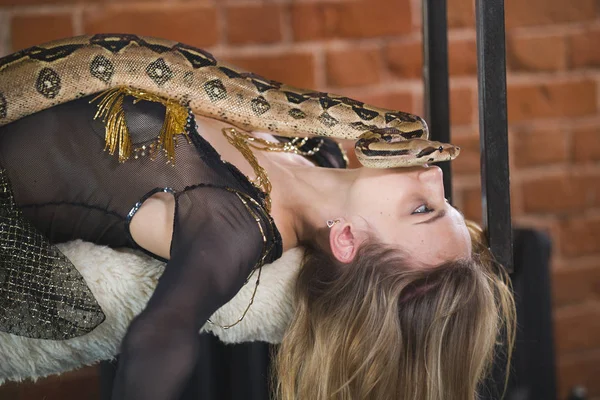 Young caucasian woman lying with a python on her face — Stock Photo, Image