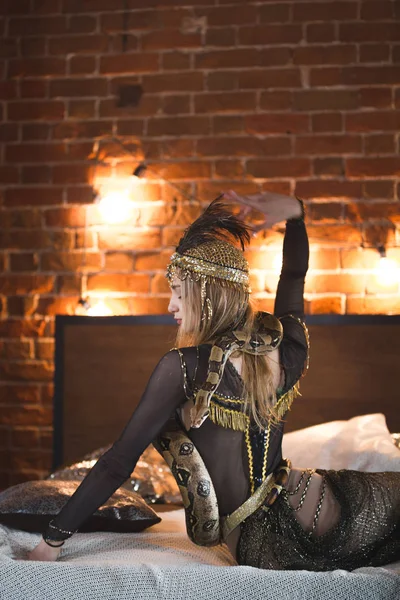 Elegante circus actrice poseren met een python op het bed — Stockfoto