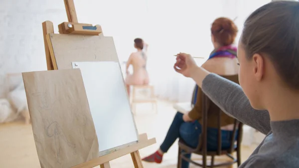 Γυναίκα καλλιτέχνης σκιαγραφώντας γυμνό μοντέλο σε σχέδιο studio — Φωτογραφία Αρχείου