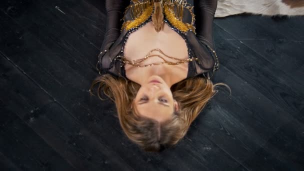 Jovem mulher bonita deitada no chão com python em um estúdio — Vídeo de Stock