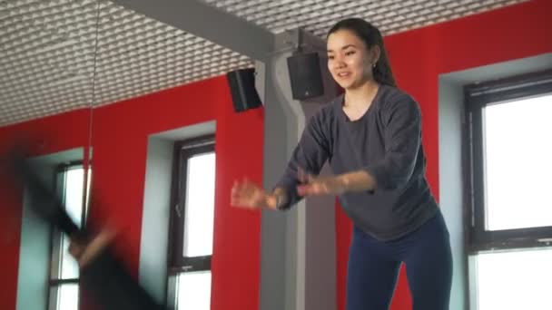 Trener żeńskiej pomóc człowiekowi z nogi wzmocnienia ćwiczenia w fitness Klasa — Wideo stockowe