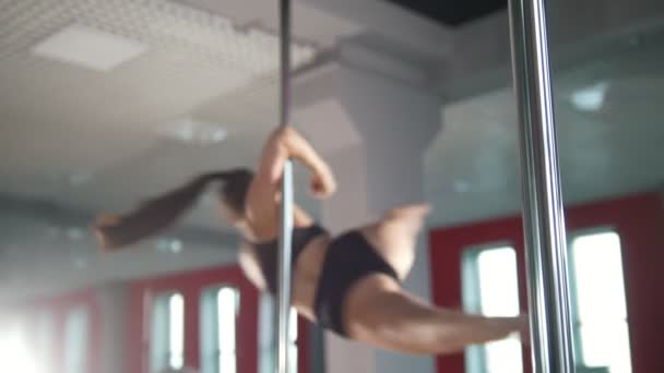 Young woman performing exercises with a pole in a studio — Stock Video