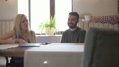Genç çift kafede kahve fincan alır