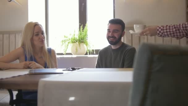 Jovem casal caucasiano leva as xícaras de café no café — Vídeo de Stock