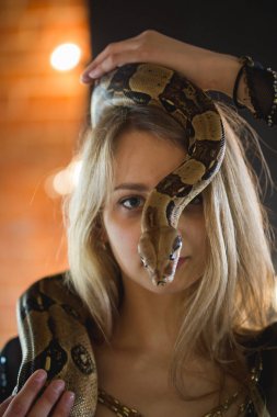 Yüzünde bir python ile güzel genç kadın portresi
