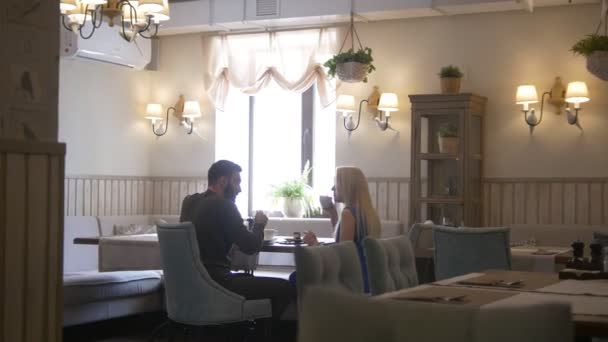 Молодая пара обедает в кафе официантка проходит — стоковое видео