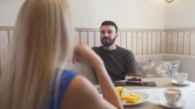 Kafede kadın konuşurken önünde Beyaz delikanlı