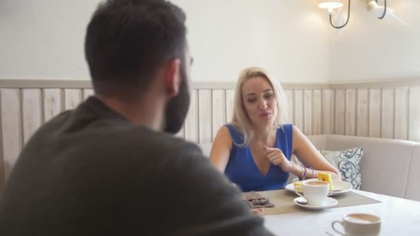 Feliz casal caucasiano tomando café com sobremesas em um encontro no café — Vídeo de Stock
