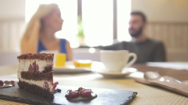 Dolce torta affettata sul piatto davanti alla coppia godendo il caffè al caffè — Video Stock