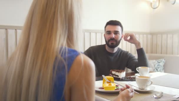 Joven hombre caucásico delante de la mujer hablando en el café y mirándose mutuamente — Vídeo de stock