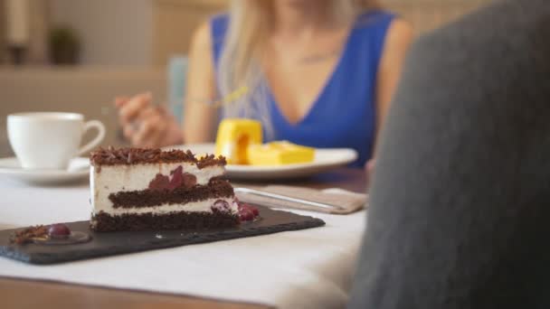 Кусок сладкого торта перед женщиной пытается десерт в кафе — стоковое видео