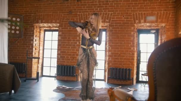 Young woman dances a belly dance in front of a snake in a studio — Stock Video