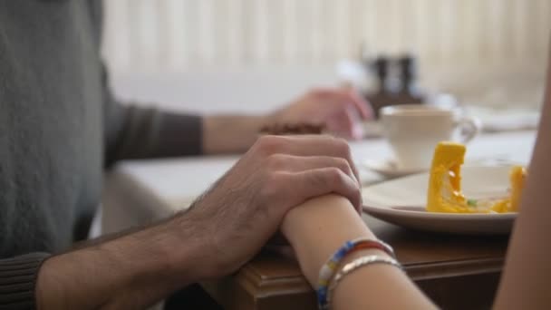 Håller händerna på unga par i caféet njuter desserter — Stockvideo