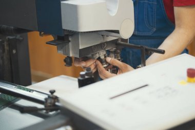 Makine baskı donanımları ile çalışan kişi elinde