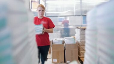 Kadın işçi kağıt tipografi kutusundan büyük bir deste ortaya konuyor