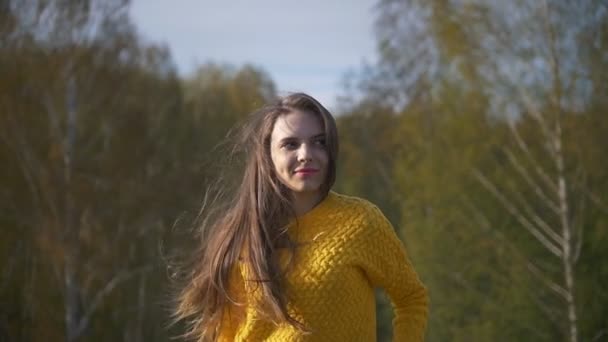 Joven mujer de pelo largo sonriendo en el bosque — Vídeo de stock