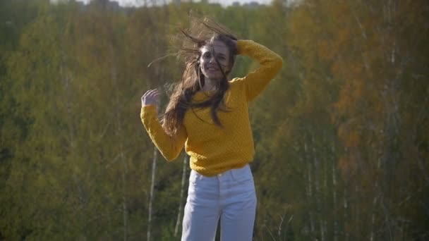 Молодая счастливая женщина с длинными волосами на холме — стоковое видео