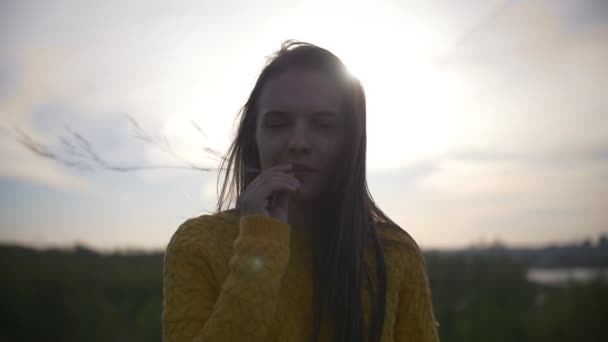 Joven mujer feliz con el pelo largo en el campo de primavera al atardecer — Vídeo de stock