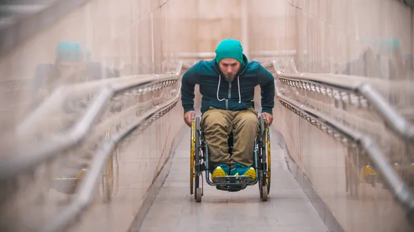 Людина з обмеженими можливостями в інвалідному візку встає на довгий спеціальний пандус — стокове фото