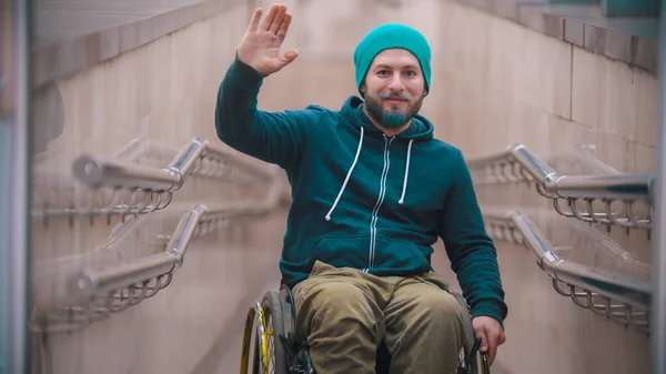 Людина з обмеженими можливостями в інвалідному візку махає рукою — стокове фото