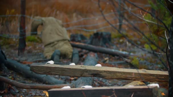 Dead soldier lying on the iron wire - piece of log on a foreground — Stock Video