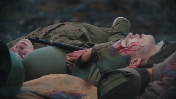 19-10-2019 RUSIA, REPÚBLICA DE TATARSTÁN: muchos soldados heridos cubiertos de sangre yaciendo en el suelo quemado del bosque - detrás del escenario de la filmación de una película militar — Vídeos de Stock