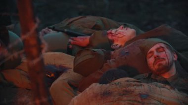 19-10-2019 Rusya, Tataristan Cumhuriyeti: askeri film çekiminin sahne arkasında, şenlik ateşinin yanında kan içinde yatan bir sürü ölü asker.