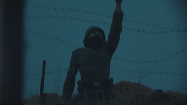 19-10-2019 Rusko, Tatarská republika: Voják stojící v noci v zákopu na hlídce za železným drátem a střílející z pistole ve vzduchu — Stock video