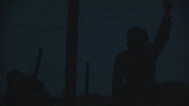 Askerler gece siperlerde devriye gezerken demir tellerin arkasında bir silah doğrultup işaret fişeğiyle ateş ediyorlardı.