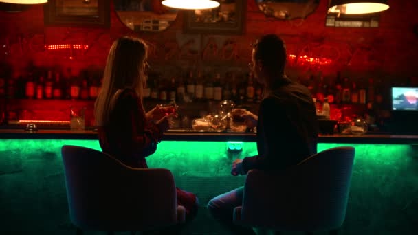 Un couple envoûtant ayant un rendez-vous dans le bar - assis à côté d'un stand et serrant leurs lunettes - applaudit — Video