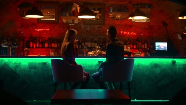 Una pareja hechizante que tiene una cita en el bar - sentada de pie y hablando — Vídeo de stock