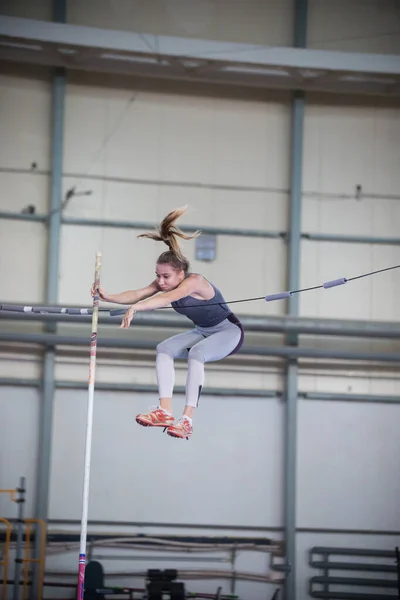 Pole vaulting indoors - young woman hits her body against the partition — Stock Photo, Image