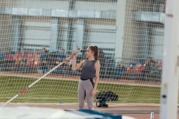 Pólo abóbada dentro de casa - jovem mulher bonita de pé perto do tapete no estádio — Fotografia de Stock