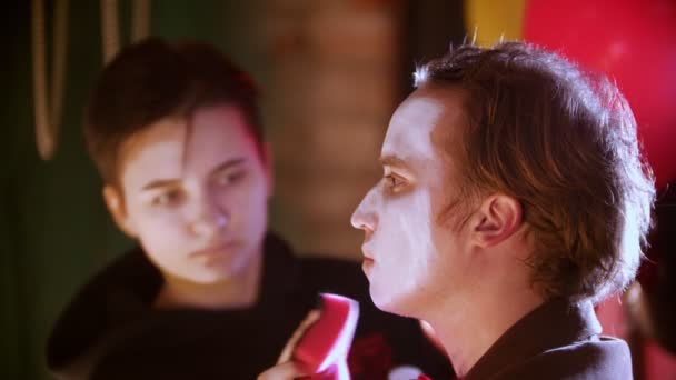 Макияж наносит краску на человека-клоуна в гримерке — стоковое видео